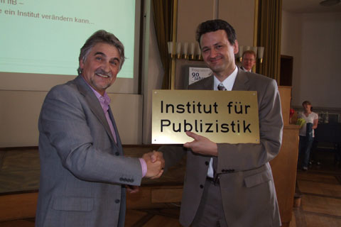 Prof. Wischenberg hands Prof. Neuberger the old sign from the institutes entrance