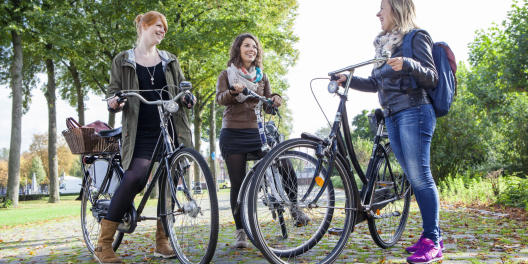 Drei Studentinnen mit Fahrrad
